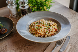 Spaghetti carbonara in a light grey stoneware bowl