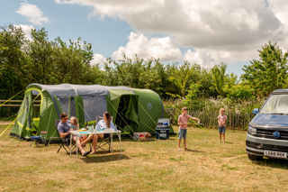 Family playing next to tent