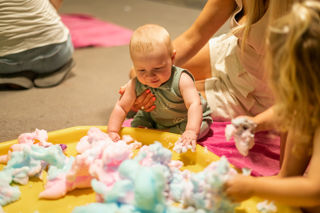 A happy baby playing in colourful foam